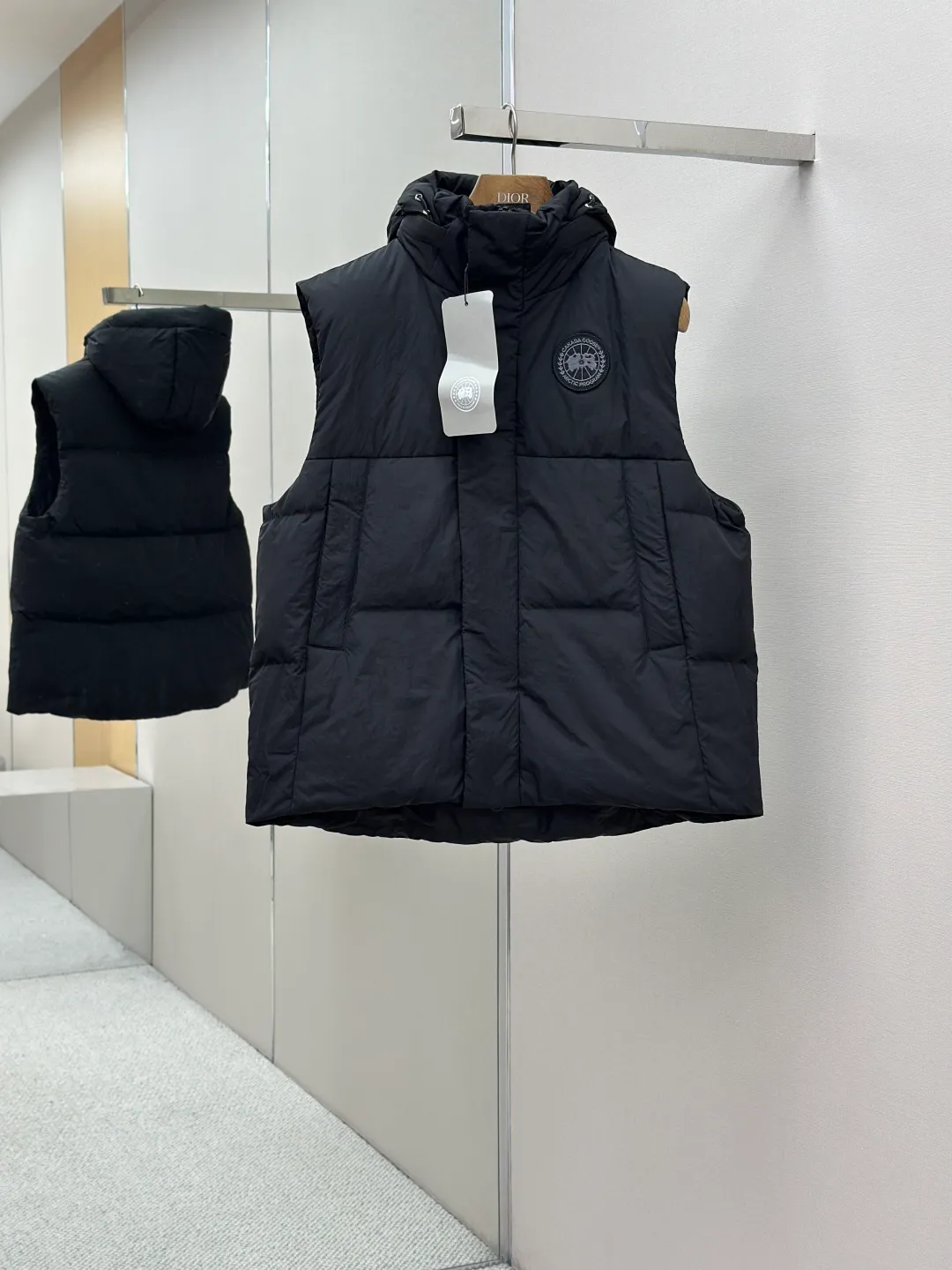P760 Canada Goose logo hooded down vest Fabric selection: The use of high-quality protective nylon fabric not only enhances the wear resistance of the surface, but also takes into account wind resistance, ensuring excellent performance in various harsh weather conditions.  90 national standard high-quality white duck down: selected high-loft down, weighing 170g, light and warm, with excellent temperature locking performance and good resilience.  Three-dimensional quilting process: Precision thread reinforcement to prevent velvet drilling and ensure that the fluffy and resilient elasticity lasts as new.  Details: Use polyester as the base for woven webbing, and use high-precision computer embroidery to decorate the brand letters on the webbing. The edges of the pattern are clear, the stitches are fine and even, and multiple layers of embroidery threads are stacked to enhance the three-dimensional effect. Accessories: Customized logo Customized zipper pendant Customized hem elastic buckle Customized snap button SIZE: S M L XL